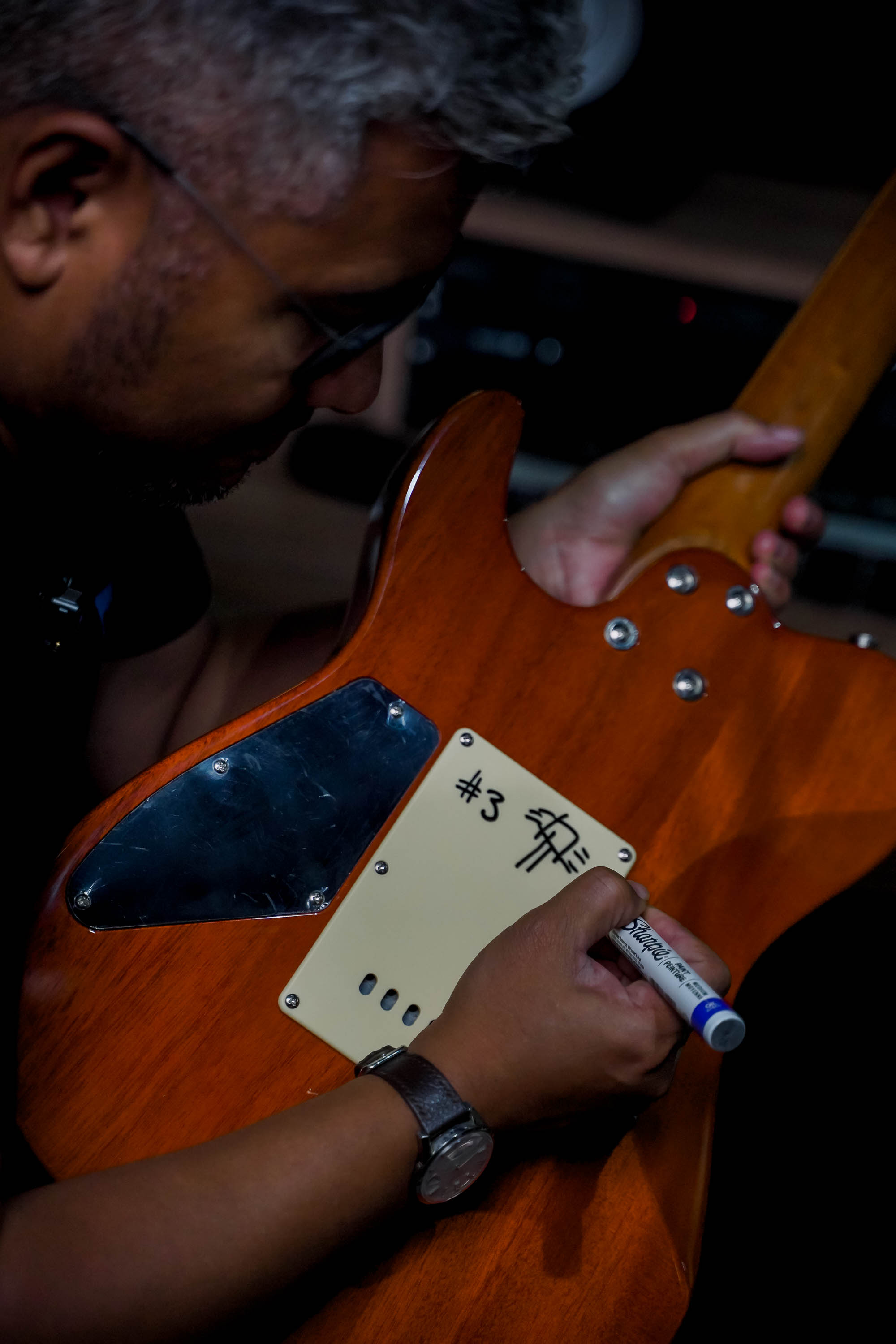 Andre Dinuth menulis nomor dan tanda tangan di pelat belakang salah satu gitar bernomor